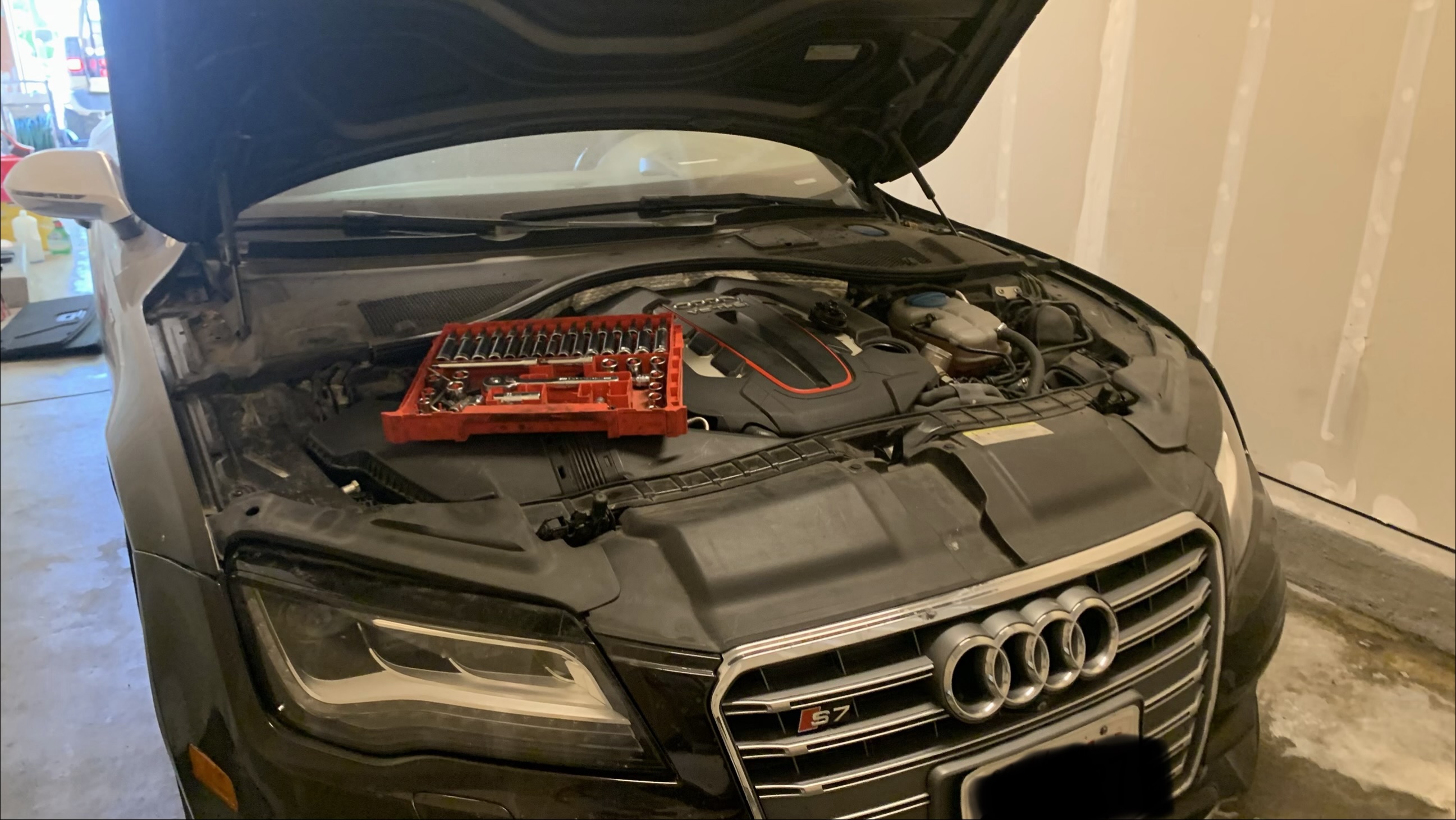 Technician working under the hood of a car